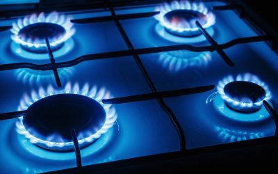 Blue flames of gas burning from a kitchen gas stove. Focus the front edge of the hotplate